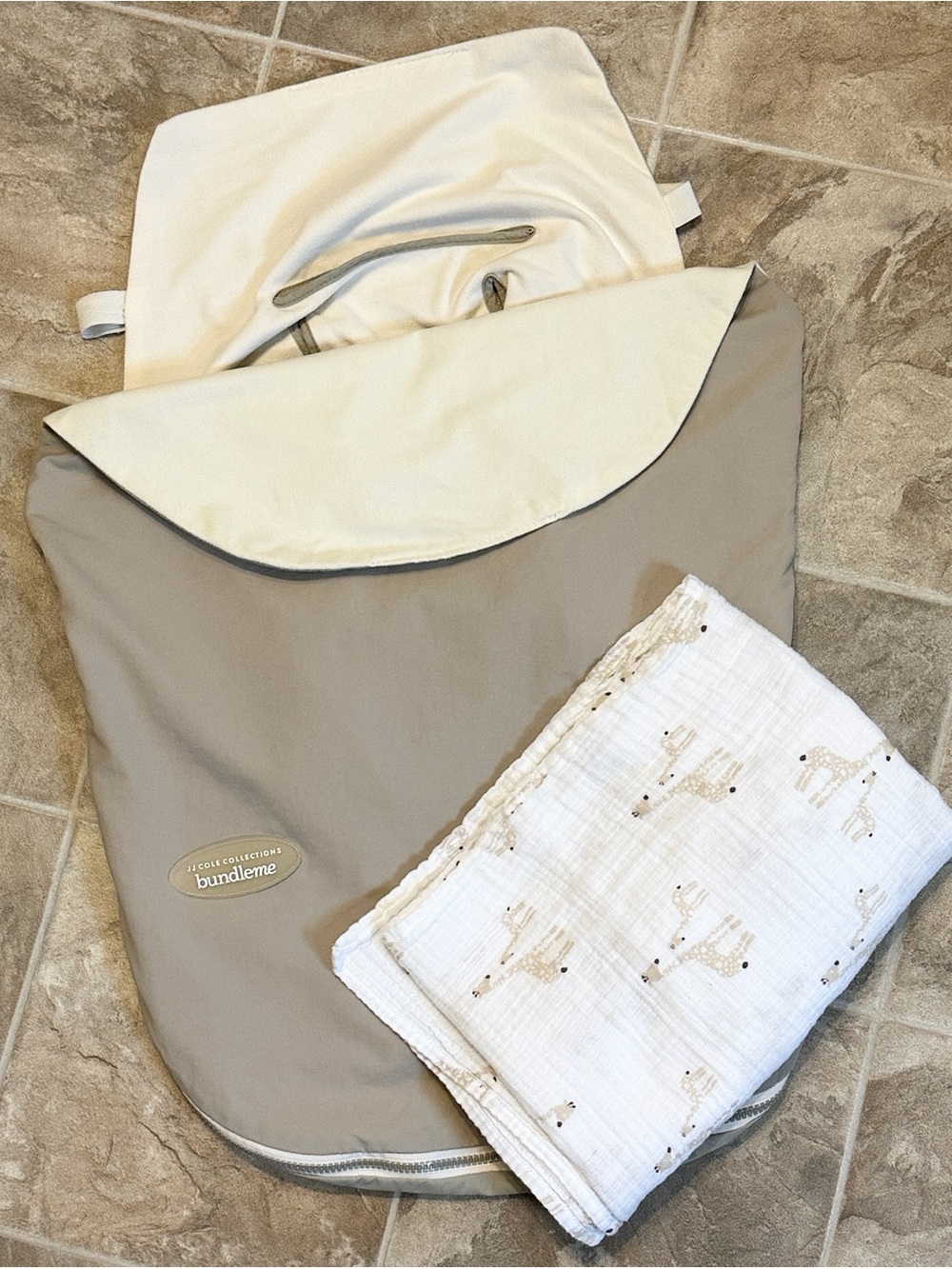 JJ Cole Bundleme lite and an aden & anais cotton muslin swaddle blanket.